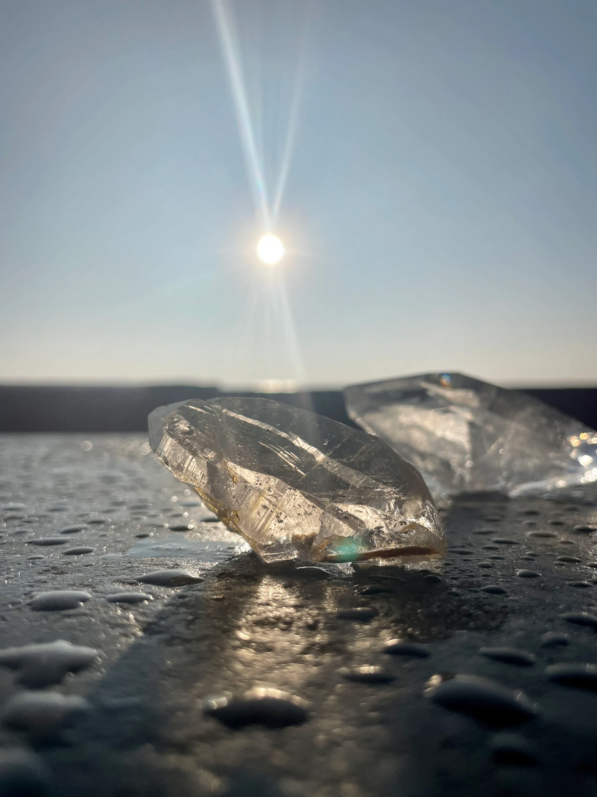 Crystal resting beside water in sunlight